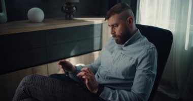 Tablet Bilgisayar üzerinde çalışan Profesyonel Finansal Uzman, Gerçek zamanlı Borsa Çizelgelerini İzleyen, Yatırım Yapan. Konforlu Yatırım Bankası Ofisinde Başarılı İşadamı.