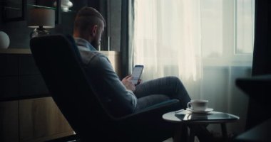 Çevrimiçi Ticaret Uygulamasında Smartphone üzerinde çalışan Finansal Analizci, Gerçek zamanlı Hisse Senedi İzleme, Borsa Çizelgeleri. Başarılı İşadamı, Konforlu Yatırım Bankası Ofisinde Çalışıyor. Sabit Çekim.