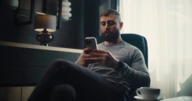 Finansal Analist Smartphone üzerinde çalışıyor, Gerçek zamanlı borsa ve borsa grafiklerini analiz ediyor, yatırım yapıyor. Başarılı İşadamı, Konforlu Yatırım Bankası Ofisinde Çalışıyor. Doli Vuruşu.