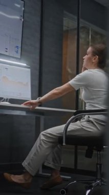 Finansal Analizci Telefonda Konuşuyor, Bilgisayar ve Tablet 'te Borsa Tablolarını Analiz Ediyor, Finansal Krizden muzdarip. İş kadını, borsa çöküşü konusunda stresli. Dikey Çekim.