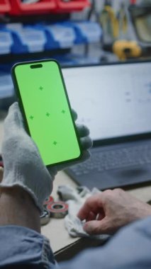 Man Checking Real-time Stocks, Exchange Market Charts dizüstü bilgisayarda ve Smartphone ile Green Screen Mock Up atölyesinde. İş Reklamcılığı için Yer Tutucu ile Görüntü Şablonu. Yakın çekim. Dikey Çekim.