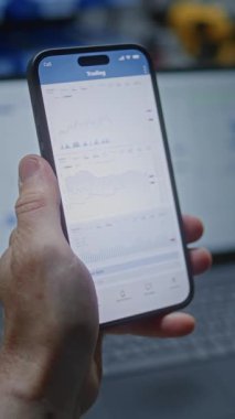 Gerçek zamanlı hisse senedi, akıllı telefon ve dizüstü bilgisayarda borsa grafikleri izleyen adam. Çalışanların Çalışma Günü 'nde İşçi Yatırım Yapması, İş ve Çevrimiçi Ticaret Birleştirmesi. Yakın çekim. Dikey Çekim.