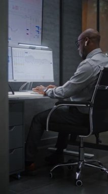 Heyecanlı Finansal Analistin Telefonu Var, Gerçek zamanlı Hisse Analizi, Çoklu İzleme Bilgisayarında Değişim Piyasası Çizelgeleri. Afrikalı Amerikalı İşadamı Başarılı Ticaret Anlaşması Yapıyor. Dikey Çekim.