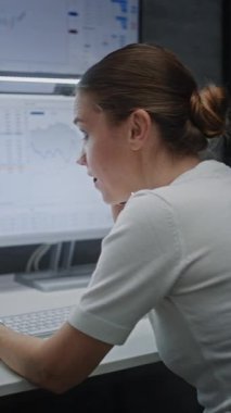 Kadın Finansal Analistin Telefon Görüşmesi Yapması, Gerçek-Zaman Hisseleri Analizi, Çoklu-İzleyici Bilgisayar ve Dijital Tablet Piyasa Çizelgeleri. Finans bürosunda çalışan bir iş kadını. Dikey Çekim.