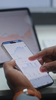 Afro-Amerikan Borsacıları Gerçek Zamanlı Borsa Analizleri, Akıllı Telefon ve Dijital Tablet Kullanımı Online Ticari Uygulama. Ofiste çalışan Yatırım Ajanı. Yakın çekim. Dikey Çekim.