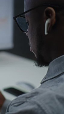 Afro-Amerikan Borsa Komisyoncusu, Online Ticaret Uygulamasında Gerçek Zamanlı Akıllı Telefon ve Çoklu Dijital Ekranları İzliyor. Ofiste çalışan bir yatırımcı. Yakın çekim. Dikey Çekim.