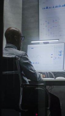 Multi-Monitor Workstation, Real-time Borsa ve Hisse Tablolarının Analizi, Telefonla Konuşan Bilgisayar üzerine çalışan Finans Analisti. Afrikalı Amerikalı İşadamı Ofiste Çalışıyor. Dikey Çekim.