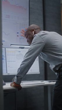 Mali Kriz Analisti, Çağrı Çağrısında Bağrışmalar, Ofisteki Borsa Tablolarının Analizi. Afro-Amerikalı İşadamı Borsa Çöküşü Hakkında Öfkeli. Dikey Çekim.