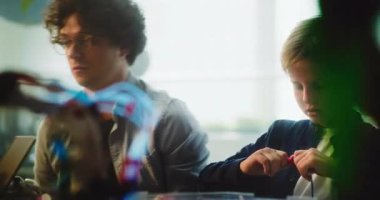 Çok Etnik Sınıfta Zeki Çocuklar ve Genç Öğretmenler Toplama İnşaatçısı BTMM Dersi. Robot Bilimleri, Yenilenebilir Enerji Modelleri ve Modern Teknolojiler Araştıran İlkokul Çocukları.