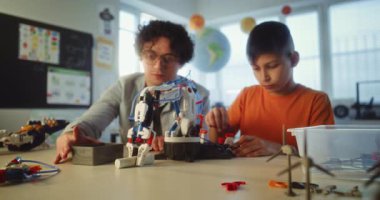 İlkokulda Etkileşimli Öğrenme ve Yaratıcı BTMM Eğitimi: Öğretmenle Robot Silah Çalışan Yetenekli Çocuk. Modern Sınıfta Bilim ve Teknoloji Dersinde Genç Okul Öğrencisi.