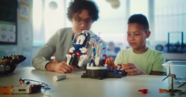 Bilim ve Teknoloji Dersi: İlköğretim Okulu Öğrenci Robot Kolu Modeli. Modern Sınıfta Akıllı Afro-Amerikan Çocuğu Eğiten Genç Öğretmen. Etkileşimli Öğrenme ve BTMM Eğitimi.