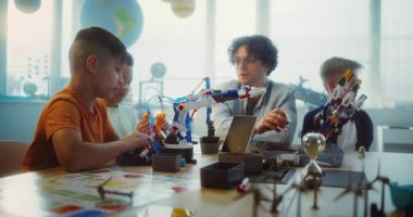 Çoklu Kültür Sınıfı 'ndaki BTMM Projeleri' nde çalışan çeşitli çocuklar ve genç öğretmenler grubu. Robot Bilimi ve Yenilenebilir Enerji Modellerini Keşfeden İlkokul Öğrencileri.