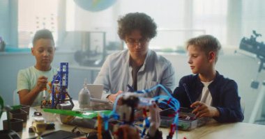 Çoklu Kültür Sınıfı 'ndaki BTMM Projeleri' nde çalışan çeşitli çocuklar ve genç öğretmenler grubu. Robot Bilimi ve Yenilenebilir Enerji Modellerini Keşfeden İlkokul Öğrencileri.