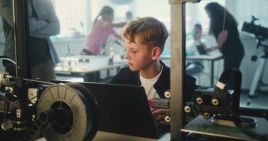 İlköğretim Okulu Öğrenci Programlama Dersinde Dizüstü bilgisayarda Gelişmiş Otomatik 3D Yazıcı Kodu. Modern Sınıfta Akıllı Genç Çocuk Teknoloji okuyor. Etkileşimli BTMM Eğitimi.