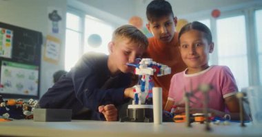Mutlu İlkokul Öğrencileri Robotik Kol Modelini Birlikte Çalışıyor. Bilim ve Mühendislik Dersinde Masada Oturan Bir grup Çocuk Çok Kültürlü Sınıfta. Etkileşimli BTMM Eğitimi.