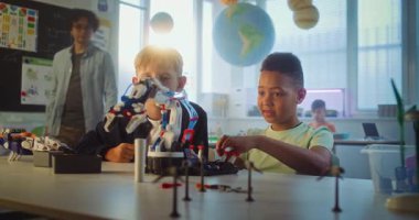 Çok Irklı Yetenekli Çocuklar Masada Oturup Robotik Kollar Modelini Çalışıyor. Modern Sınıfta Bilim ve Teknoloji Dersinde İlkokul Çocukları. Etkileşimli Öğrenme, BTMM Eğitimi.