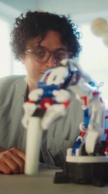 BTMM İlköğretim Eğitimi: Genç Öğretmen ile Robotik Kollar Çalışan Afrikalı Amerikalı Çocuk. Modern Sınıfta Bilim ve Teknoloji Dersinde Öğrenci. Dikey Çekim.