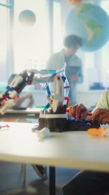 Modern Sınıfta İlkokul Öğrencisi Robotik Kol Modeli Teknoloji Dersi sırasında. Genç Afrikalı Amerikalı Çocuk Mühendis Olmayı Hayal Ediyor. Etkileşimli BTMM Eğitimi. Dikey Çekim.
