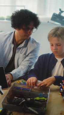 Çok Irklı Sınıfta Çocuklar ve Genç Öğretmenler Toplama İnşaatçısı BTMM Dersi. Robotik Keşfeden İlkokul Çocukları, Yenilenebilir Enerji Modelleri, Çalışan Teknolojiler. Dikey Çekim