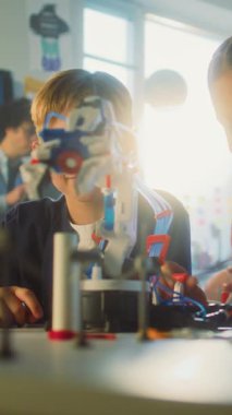 Yetenekli Oğlan ve Kız Robotik Kolları İnceleme Ekibi. İlkokul Çocukları ve Öğretmenleri Bilim ve Teknoloji Dersinde Sınıfta. İnteraktif Öğrenme, BTMM Eğitimi. Dikey Çekim.