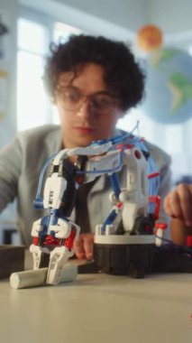 İlkokulda Etkileşimli Öğrenme ve Yaratıcı BTMM Eğitimi: Öğretmenle Robot Silah Çalışan Yetenekli Çocuk. Modern Sınıfta Bilim Dersinde Genç Öğrenci. Dikey Çekim.