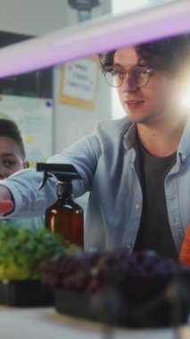 Erkek ve Kız Takımının Öğretmenleri Bitkiler üzerine Biyoloji Deneyi, Besleyici Su Spreyi. Çok Etnik Sınıfta İlkokul Çocukları Dersi sırasında. BTMM Eğitim. Dikey Çekim.