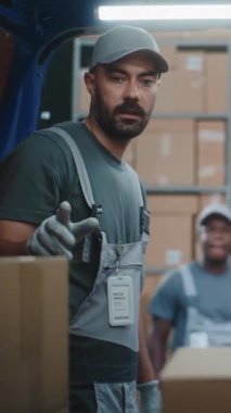 Çevrimiçi siparişlerle dolu karton kutularla dolu teslimat kamyonunun içinde bekleyen çeşitli işçiler konuşuyor, boşaltmaya hazır. Kadın Yönetici Tablet Bilgisayar Kullanıyor. Lojistik Deposu. Dikey Çekim.