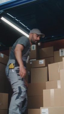 Çoklu Etnik İşçiler Karton Kutuları Çevrimiçi Siparişlerle Boşaltıyorlar, Teslimat Kamyonundan E-Ticari Mallar. Afro-Amerikan Yöneticisi Tablet Bilgisayar kullanıyor. Depo 'nun dışında çalışıyorum. Dikey Çekim.