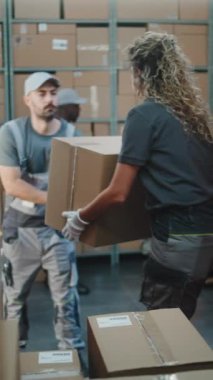 Çoklu etnik kökenli işçiler karton kutuları çevrimiçi siparişlerle, E-ticaret ürünleri teslimat kamyonu ve palet kamyonu ile boşaltıyorlar. Lojistik Deposu 'nun dışında. Teslimat Servisi 'nde çalışıyorum. Dikey Çekim.