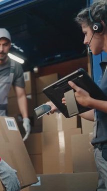 Çoklu Etnik İşçiler Karton Kutuları Çevrimiçi Siparişlerle Yüklüyor, E-Ticaret Malları Teslimat Kamyonu 'nda. Kadın Yönetici Tablet Bilgisayar ve Barkod Tarayıcı kullanıyor. Lojistik Perakende Deposu. Dikey Çekim.