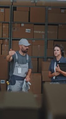 Lojistik Deposu 'nun dışında çeşitli çalışanlar karton kutular, online siparişler, e-ticaret ürünleri taşıyan teslimat kamyonu boşaltıyorlar. Dijital Tablet ve Barkod Tarayıcı kullanan Kadın Yönetici. Dikey Çekim