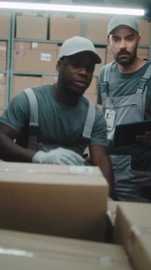 Çoklu Etnik İşçiler Karton Kutuları Çevrimiçi Siparişlerle Tarıyor, E-Ticari Mallar Teslimat Kamyonunda Barkod Tarayıcı kullanarak, Tablet Bilgisayarda Detayları Kontrol Ediyor. Lojistik Deposu. Dikey Çekim.