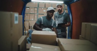 Çoklu Etnik İşçiler Karton Kutuları Çevrimiçi Siparişlerle Tarıyor, E-Ticari Mallar Teslimat Kamyonunda Barkod Tarayıcı kullanarak, Tablet Bilgisayarda Detayları Kontrol Ediyor. Lojistik Perakende Deposu 'nun dışında.