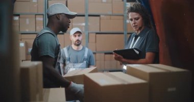 Çoklu Etnik İşçiler Karton Kutuları Çevrimiçi Siparişlerle Boşaltıyorlar, Teslimat Kamyonundan E-Ticari Mallar. Kadın Yönetici Tablet Bilgisayar ve Barkod Tarayıcı kullanıyor. Lojistik Perakende Deposu 'nun dışında.