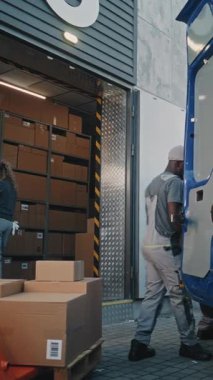 Çoklu etnik kökenli işçiler karton kutuları çevrimiçi siparişlerle yüklüyorlar ve Palet Kamyonu 'ndan E-Ticari Mallar. Express Teslimat Servisi. Lojistik Deposu 'nun dışında. Tam doz. Dikey Çekim.