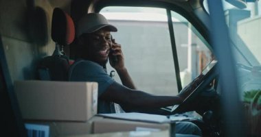Cep telefonuyla konuşan, evrakları dolduran, online siparişleri teslim eden, e-ticaret ürünleri getiren, yiyecek getiren Afrikalı Amerikan Nakliye Aracı Şoförü. Express Teslimat Servisi 'nde çalışan Mutlu Adam