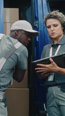 Lojistik Perakende Deposu: Afro-Amerikan İşçi Karton Kutuları Çevrimiçi Siparişlerle, E-Ticari Ürünlerle Boşaltıyor. Tablet Bilgisayar kullanan kadın envanter uzmanı. Teslimat servisi. Dikey Çekim.