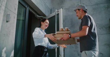 Modern Ofis Binası 'nda çalışan Teslimat Servisi' nden kahve ve pizza alan mutlu iş kadını. Teslimatçı Restoran Yemeği Getiren, Akıllı Telefon kullanarak Başarılı Teslimat 'ı Onaylıyor. Yavaş Hareket