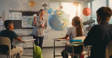 Çok Irklı Sınıfta Bilim Dersinde Akıllı Çocukları Eğiten Bayan Öğretmen. İlkokul çocuğu, Dünya Modelini Kullanarak Sınıfın Önündeki Yeşil Enerji Kaynaklarını Sunar. BTMM Eğitim. Doli Vuruşu.