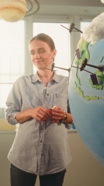 Afrika kökenli Amerikalı çocuk, yenilenebilir enerji kaynaklarını sunuyor Dünya 'yı 3 boyutlu Rüzgar Türbinleri ve Güneş Panelleri Modelleri ile kullanıyor. İlkokul çocukları öğretmenle ekoloji okuyor. Dikey Çekim