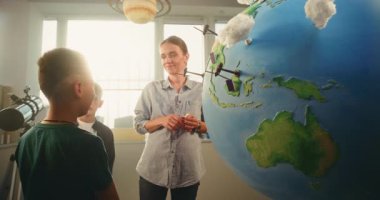 STEM Bilim Dersi: Afro-Amerikan Çocuk, Yenilenebilir Enerji Kaynaklarını sunuyor Dünya 'yı 3 boyutlu Rüzgar Türbinleri ve Güneş Panelleri Modelleri ile Kullanıyor. İlkokul Çocukları Bayan Öğretmenle Ekoloji okuyor