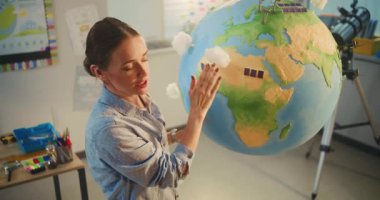 Sınıfta Dünya Gezegeni 'nin Modelini kullanarak Fen Eğitimi ve Yenilenebilir Enerji Kaynakları Dersleri. Dünya 'daki Rüzgâr Türbinleri ve Güneş Panelleri' nin minyatür 3D modelleri. Yüksek Açı.