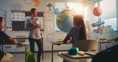 Bilim dersi: Dünya Gezegeni Modelini Kullanan Akıllı Çocukları Eğiten Kadın Öğretmen. Modern Çoklu Etnik Sınıflar Odasında İlkokul Çocukları Yenilenebilir Enerji ve Güneş Sistemi Okuyor. STEM Eğitimi.