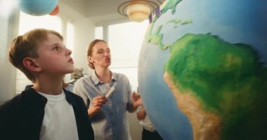 STEM Bilim Dersi: Akıllı Çeşitli Çocukları Eğiten Kadın Öğretmenler Dünya 'yı Minyatür 3 boyutlu Rüzgar Türbinleri ve Güneş Panelleri Modelleri ile Kullanıyor. İlkokul Çocukları Yenilenebilir Enerji ve Ekoloji okuyor.