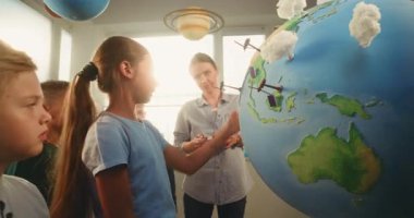 BTMM Sınıfı: Yetenekli Kız Yeşil Enerji Kaynaklarını Sunar Dünya Modelini 3 boyutlu Rüzgar Türbinleri ve Güneş Panelleri Modelleri ile Kullanıyor. İlkokul öğrencileri bayan öğretmenden yenilenebilir enerji öğreniyor..