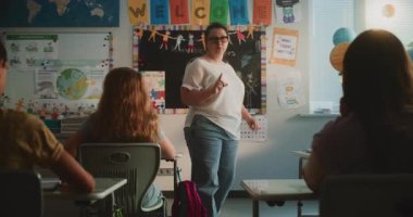 Bayan Öğretmenlik Dersi, İlkokul Çocuklarına Ekoloji Dersi. Masalarda oturan, Yenilenebilir Enerji Kaynakları öğrenen, Öğretmen 'i dinleyen bir grup genç kız ve erkek..