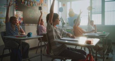 İlkokul öğrencileri masada oturuyor, öğretmenden ders dinliyor, doğru cevabı vermek için ellerini kaldırıyor. Modern Sınıfta Bilim, Coğrafya okuyan Akıllı Çeşitli Çocuklar Takımı.