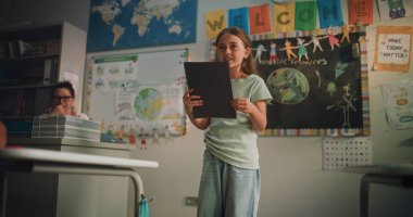 Not Defteri Konuşan İlkokul Kızı, Sınıf Arkadaşlarının Önünde Ekoloji Bilgilerini Gösteren ve Bayan Öğretmen. Çevre Bilimi Dersinde Akıllı Öğrenci Ödevini Sunar. Doli Vuruşu.