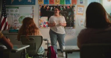 Bayan Öğretmen İlkokul Öğrencilerine Yenilenebilir Enerji Kaynakları Konusunda Ders Veriyor. Modern Renkli Sınıfta Masalarda oturan, Ekoloji okuyan, Öğretmeni Dinleyen Zeki Çeşitli Çocuklar.