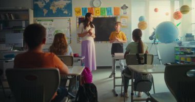 STEM Yenilenebilir Enerji Sınıfı: İlköğretim Okulu Öğrencisi Sınıf Arkadaşları ve Kadın Öğretmenler Odası Önündeki Enerji Kaynakları Hakkında Konuşuyor. Çeşitli Çocuklar Ekoloji ve Bilim Çalışıyor.